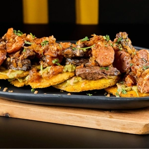 Tostones Con Entraña, Chorizo & Guacamole.