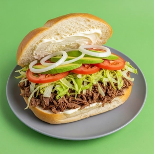 Barbacoa Torta with shredded beef, lettuce, tomato, and avocado in Dallas.