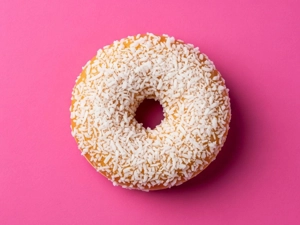Coconut donut with visible coconut flakes on top, from a restaurant in Dallas.