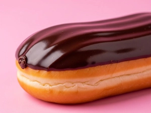 Long John with chocolate glaze on a pink background in Dallas.