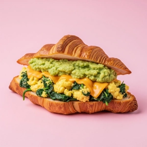 Veggie Cheese Croissant with scrambled eggs, spinach, and avocado mash in Dallas.