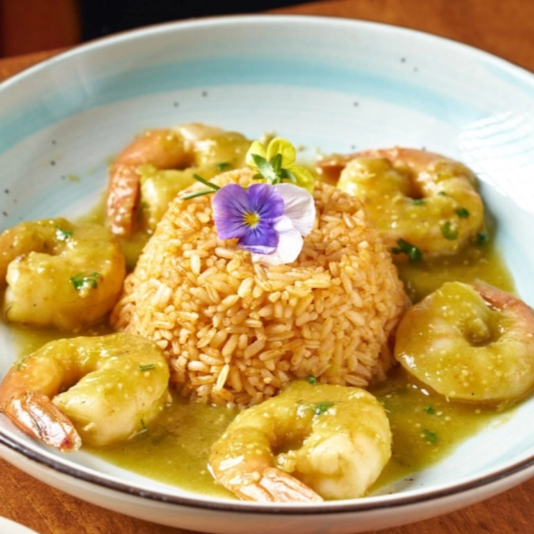 Camarones Yucatecos with shrimp in green sauce and rice, garnished with an edible flower in Wantagh.