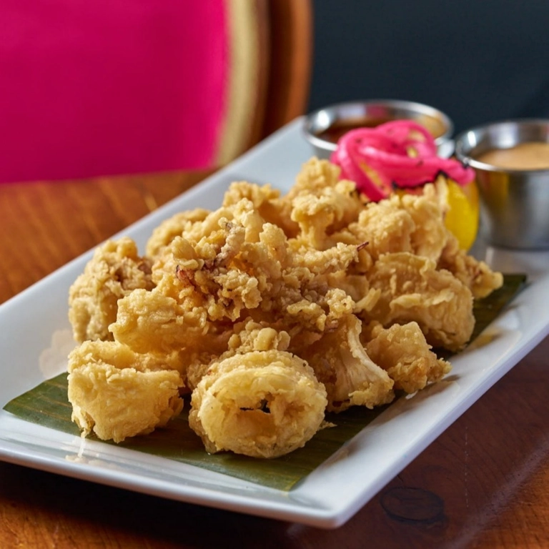 Fried Calamari with crispy batter and lemon slices served on a white plate in Wantagh.