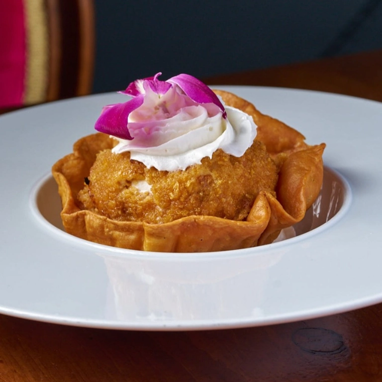 Fried Ice Cream with a crispy breaded coating, topped with whipped cream and a pink flower in Wantagh.