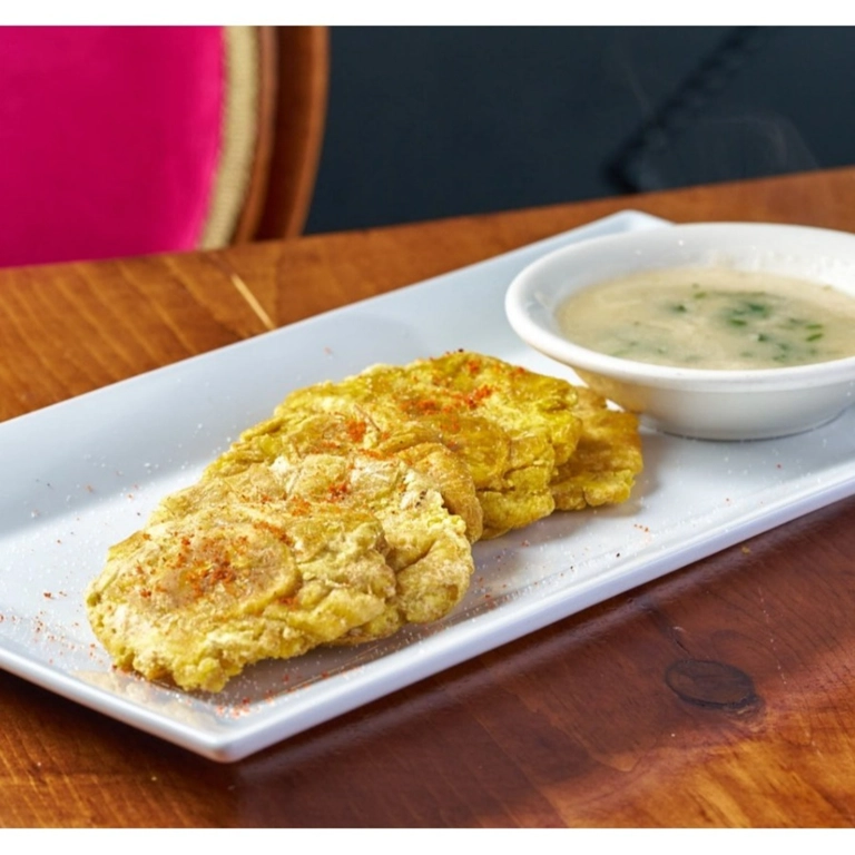 Tostones with a side of creamy dipping sauce on a white plate in Wantagh.