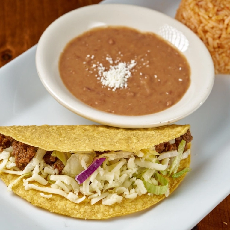 Kid Tacos with ground beef, shredded cheese, and a side of refried beans in Wantagh.