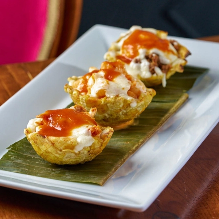 Tostones Rellenos with cheese and tomato sauce on a banana leaf in Wantagh.