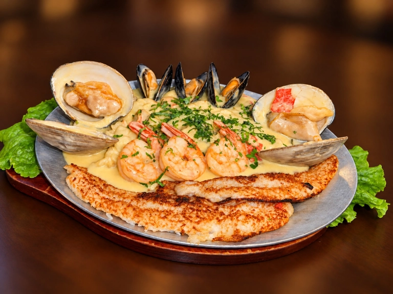 Filete Marinado con camarones, almejas y mejillones en salsa sobre un plato. Cocina desconocida en ciudad desconocida.