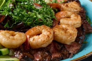 Ensalada mar y tierra con camarones y carne sobre lechuga fresca. La ciudad no se puede determinar.