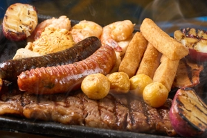 Parrillada Sabor a Colombia con chorizo, morcilla, papas y yuca en parrilla.