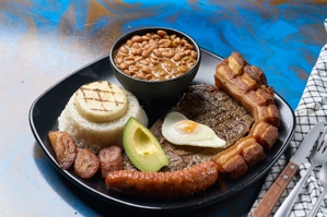 Bandeja Sabor a Colombia con carne asada, arroz, frijoles, chicharrón y aguacate. Cocina colombiana.