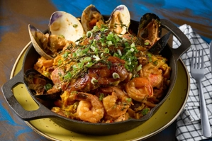 Paella Sabor a Colombia con arroz amarillo, camarones, almejas y pollo visible en la imagen.