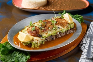 Churrasco caleño con guacamole, camarones y limón. Cocina caleña en una bandeja de metal.