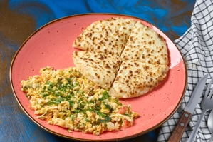 Huevos pericos con tomate y cebolla, acompañados de arepa y queso. Cocina colombiana.