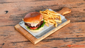 Hamburguesa de res con lechuga y tomate, acompañada de papas fritas. Cocina desconocida en ciudad desconocida.