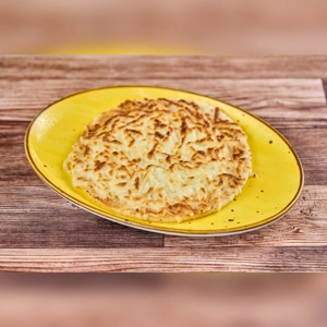 Arepa Tela Con Queso on a yellow plate, featuring a golden-brown crust and melted cheese. Cuisine type and city unknown.