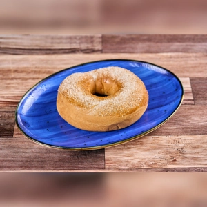 Roscon de Arequipe Grande on a blue plate, topped with sugar, showing a golden brown crust. Unknown cuisine type and city.