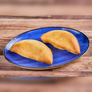Cambray pastries on a blue plate, featuring a golden-brown crust. Cuisine and city unknown.
