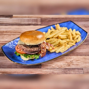 Hamburguesa Antojitos with bacon, lettuce, and crinkle-cut fries on a blue plate. Cuisine type and city unknown.
