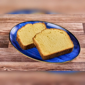 Mantecada shortbread slices on a blue plate, showing a golden crust and soft interior. Cuisine and city unknown.