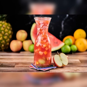 Salpicon with visible chunks of watermelon and apple in a glass pitcher. Unknown cuisine in an unknown city.