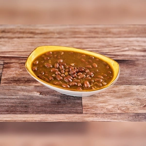 Large bowl of beans in sauce, visible in a yellow-rimmed dish. Unknown cuisine in an unspecified city.