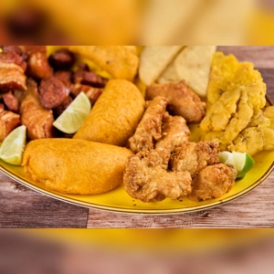 Antojitos Sampler with empanadas, fried chicken, tostones, and chorizo. Cuisine type and city unknown.