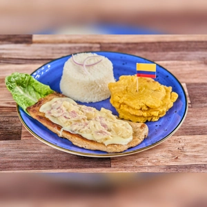 Lomo Haiwaiiano with melted cheese and ham, served with rice and plantains. Colombian cuisine.