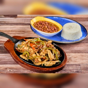 Fajitas de Pollo with grilled chicken, bell peppers, and onions served with rice and beans. Cuisine type and city unknown.