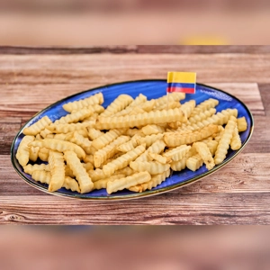 Extra French fries on a blue plate with a Colombian flag toothpick, crinkle-cut and golden brown.