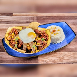 Cazuela de Frijoles with beans, fried egg, and rice on a blue plate. Cuisine type and city unknown.