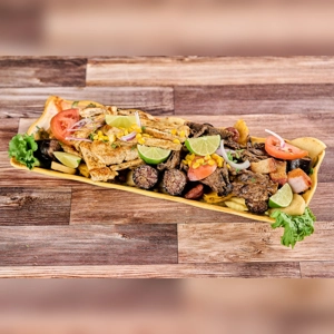 Picada Familiar with grilled meats, lime wedges, and plantains. Cuisine type and city unknown.