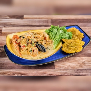 Cazuela de Mariscos with shrimp, mussels, and plantains, served with lettuce in an unknown city.