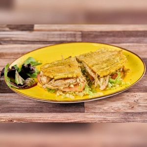 Toston Loco De Pollo with shredded chicken, lettuce, and tomatoes on a yellow plate. Unknown cuisine in an unknown city.