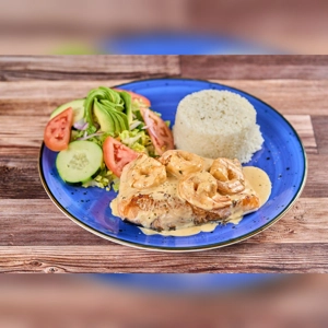 Salmon in shrimp sauce with visible shrimp and creamy sauce, served with rice and salad on a blue plate. Cuisine and city