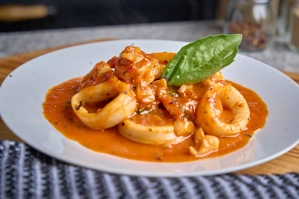 Seafood platter with shrimp, calamari, and red sauce on a white plate in New York.