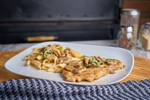 Chicken Marsala with mushrooms and pasta, served at a restaurant in New York.