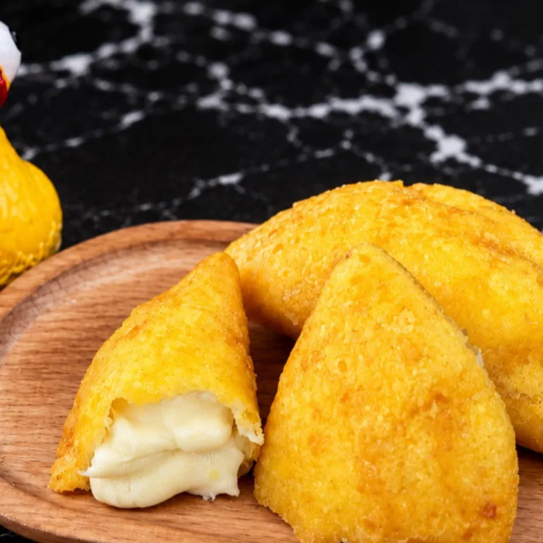 Empanada de queso con masa dorada y relleno de queso derretido, sobre un plato de madera. Cocina desconocida en ciudad
