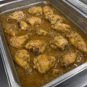 Pollo guisado with visible chicken pieces and tomato sauce in Carrollton.