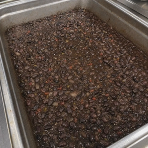 Frijoles negros con trozos de cebolla y pimientos rojos en un restaurante latino en Carrollton.
