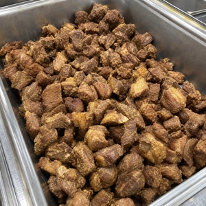 Chicharrón pieces in a metal tray, showcasing crispy pork skin and meat, at a Latin restaurant in Carrollton, TX.