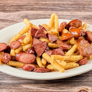 Salchipapa Mixta with sliced sausages and French fries on a plate in Union City.