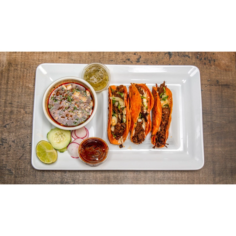 Tacos de Birria with mozzarella cheese and onions, served with consomme, lime, and salsa in Roanoke.