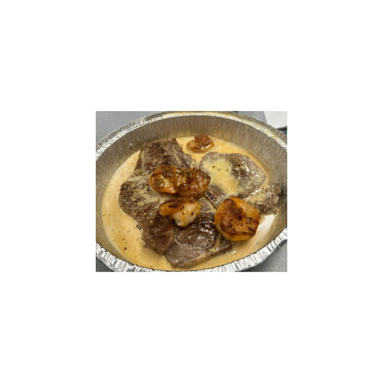Steak with shrimp topped with cheese dip, featuring grilled shrimp and T-bone steak in Roanoke.
