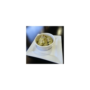 Guacamole with visible onions and tomatoes in a white bowl, served in Roanoke.