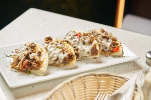 Arepa mechuda colombiana con carne desmechada y queso derretido en Ridgewood, NY.
