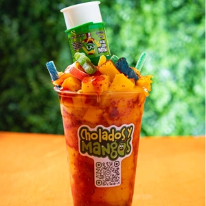 Mangoloco with mango chunks, colorful candy, and spicy sauce at Cholados y Mangos in Jackson Heights.
