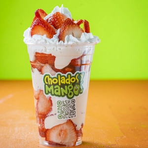Fresas con Crema with sliced strawberries and whipped cream in a cup from Cholados y Mangos in Jackson Heights.
