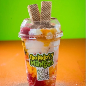 Cholado Milo with colorful fruit pieces and wafer sticks in Jackson Heights.