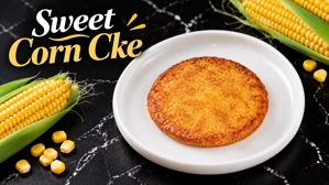Arepa de chócolo colombiana con maíz visible en un plato blanco.